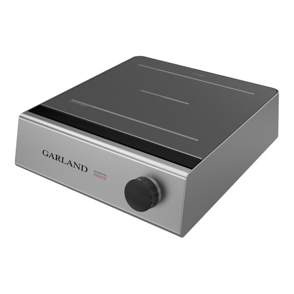 A stainless steel electric induction countertop range with a black glass top and a single control knob.