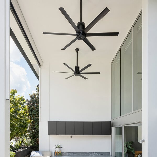 A Big Ass Fans black aluminum i6 outdoor ceiling fan in a room on an outdoor patio.