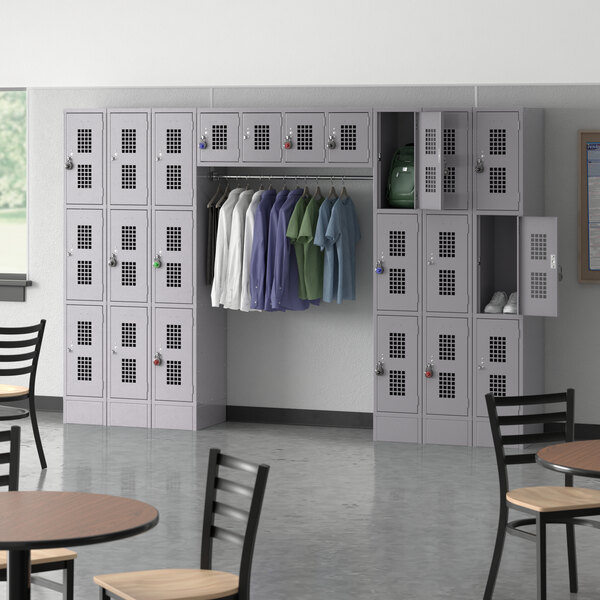 A room with a Regency gray locker with 22 compartments and garment rack and chairs.