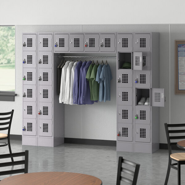 A room with Regency Space Solutions gray lockers and a garment rack with clothes hanging on it.