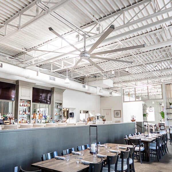 A large room in a farm-to-table restaurant with Big Ass Fans above tables and chairs.