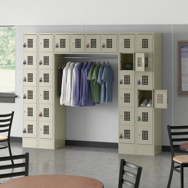 A locker room with Regency Space Solutions beige lockers and a garment rack.