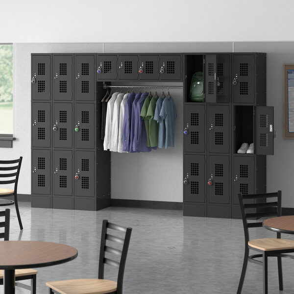 A room with a Regency Black 3 Tier Locker and chairs.