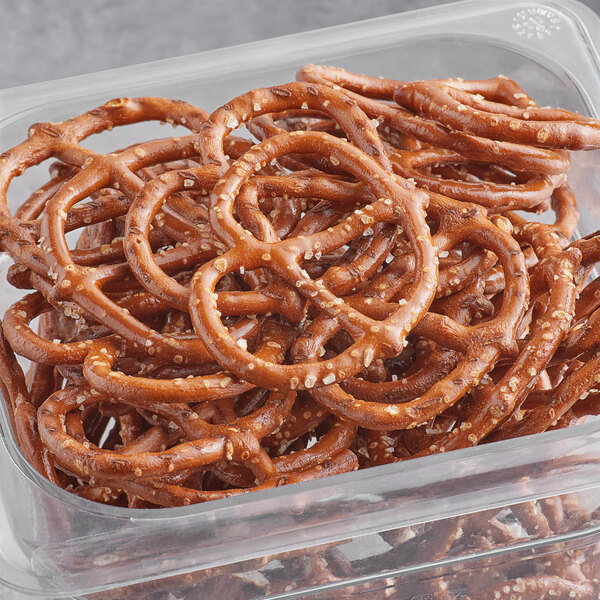 A plastic container of Good's Super Thin Pretzels on a counter.