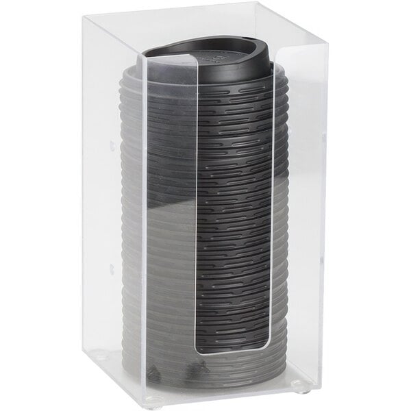 A clear plastic container holding black cylinder lids.