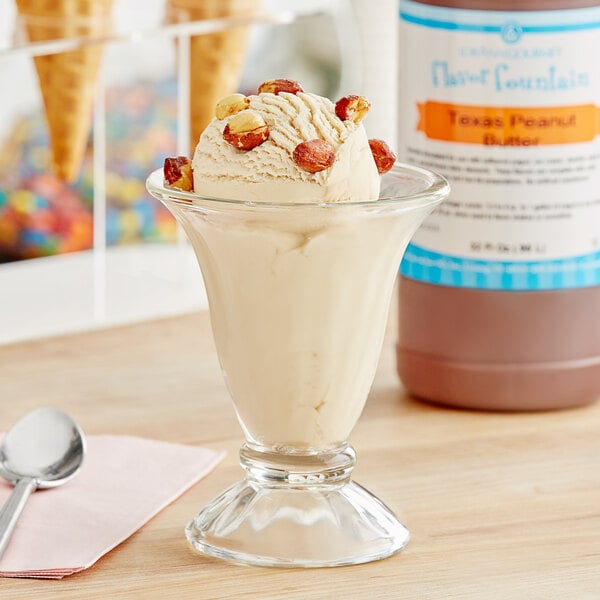 A glass cup of ice cream with LorAnn Texas Peanut Butter flavor syrup on it.