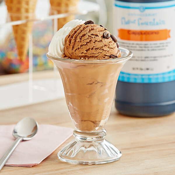 A glass cup with a scoop of brown and white ice cream drizzled with LorAnn Cappuccino flavoring.