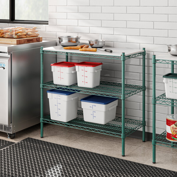 A kitchen with a metal Regency shelving unit with white and green plastic shelves.