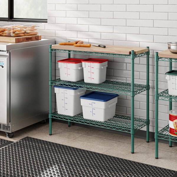 A Regency green epoxy metal shelving unit with a removable wooden shelf on a white kitchen counter.