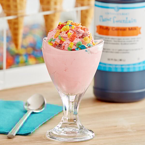 a pink ice cream in a glass with candy on top