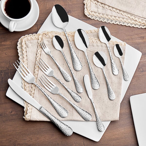 A group of Acopa Inspira stainless steel cocktail/oyster forks on a table.