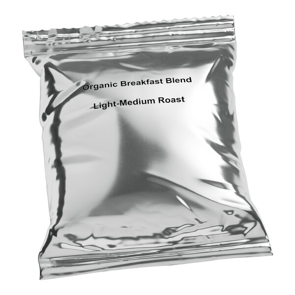 A silver Crown Beverages coffee packet with black text that reads "Organic Breakfast Blend" and "Light Roast"