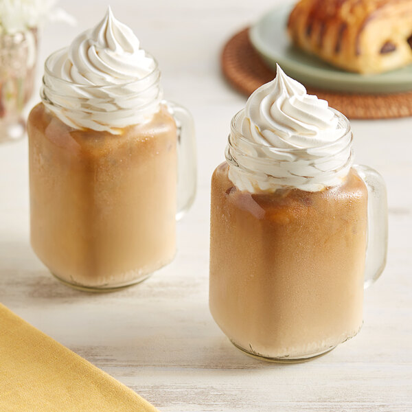 Two glasses of brown Crown Beverages Organic Donut Shop coffee with whipped cream on top.