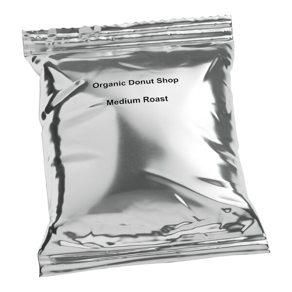 A silver Crown Beverages bag with black text that reads "Organic Donut Shop Medium Roast Coffee"