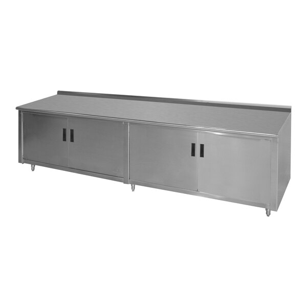 An Advance Tabco stainless steel work table with an enclosed base and hinged doors.