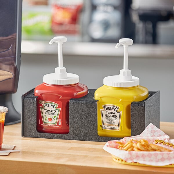 A black ServSense countertop condiment pump organizer with two sections holding ketchup and mustard bottles.