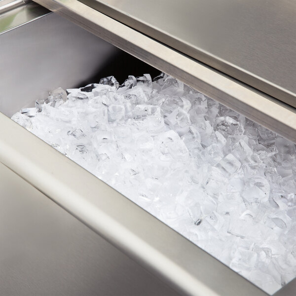 An Eagle Group underbar ice bin with ice in a stainless steel container.