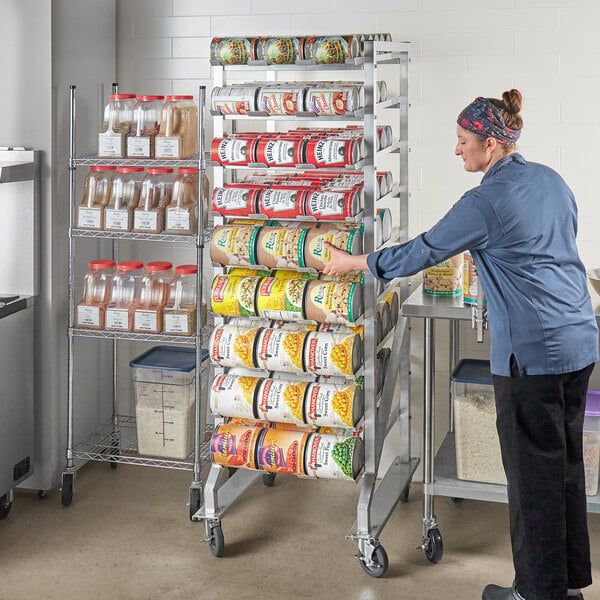 A woman assembling a Steelton mobile aluminum can rack for #10 and #5 cans.