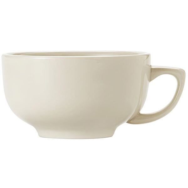 A close-up of a Libbey Porcelana Cream white porcelain jumbo cup with a handle.