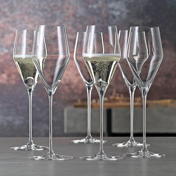A group of Spiegelau flute glasses on a table.