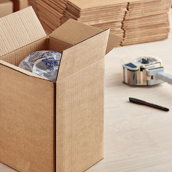 A Lavex corrugated cardboard shipping box on a table with a plastic bag inside.