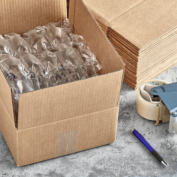 A Lavex corrugated shipping box with plastic wrap and a pen next to a stack of cardboard boxes.