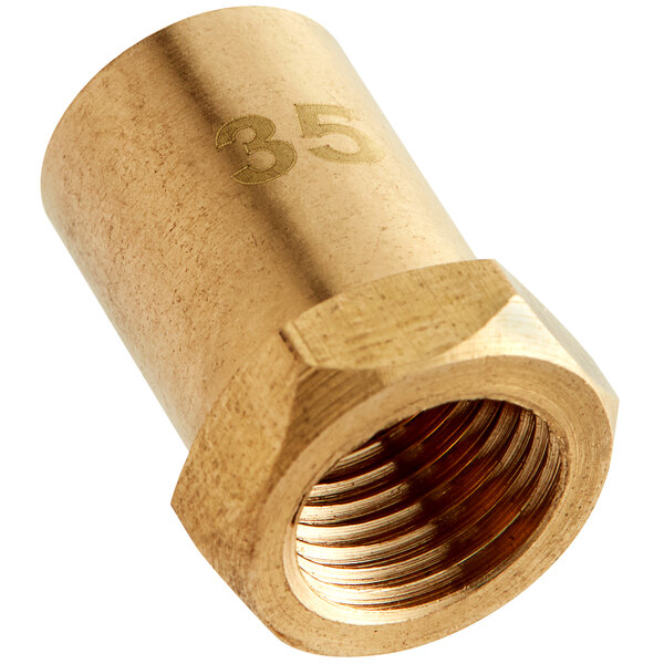 A gold brass Cooking Performance Group #35 burner orifice nut.