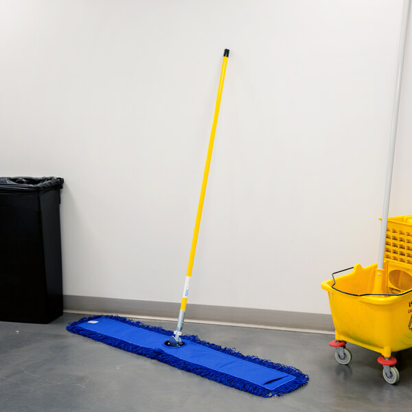 A yellow bucket with a handle and a Lavex swivel snap wire dust mop frame on a white wall.