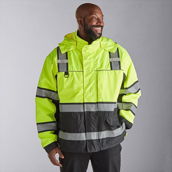A man wearing a Cordova Hi-Vis lime yellow quilted parka with reflective stripes.