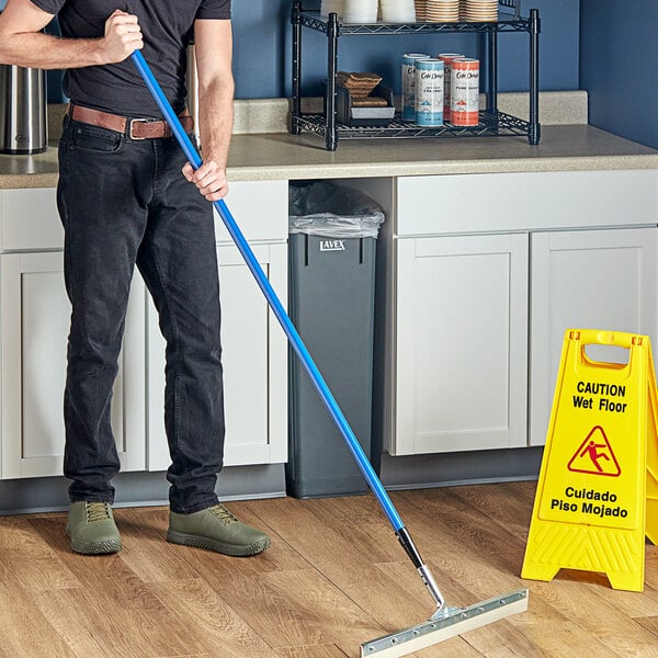 A man using a Lavex threaded metal broom handle.