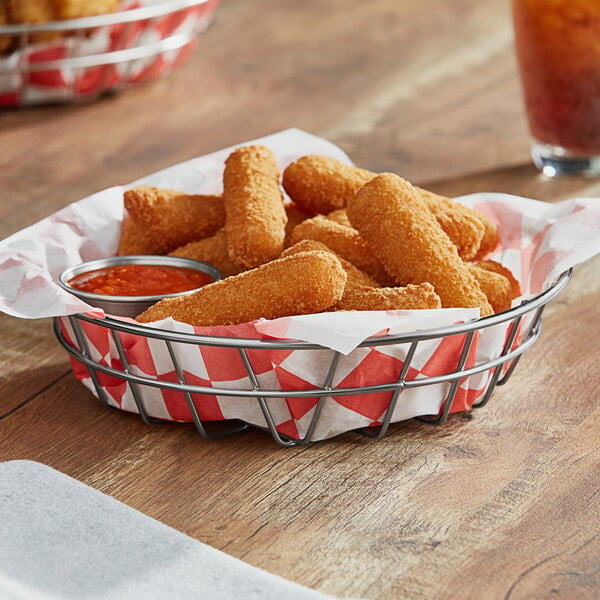 An American Metalcraft stainless steel wire basket filled with fried food on a table in a pizza parlor.