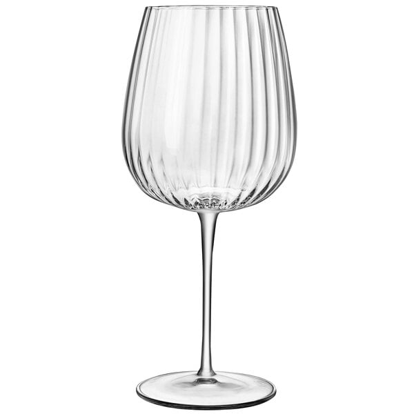 A clear Luigi Bormioli gin and tonic glass with a thin stem.