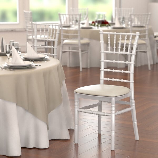 A white chair with a beige cushion.