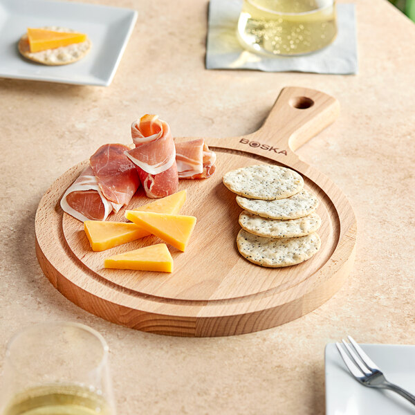 A Boska beech wood serving board with cheese and meat on it.