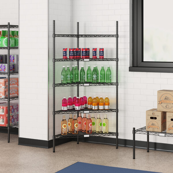 A Regency black wire triangle shelf with beverages and boxes on it.