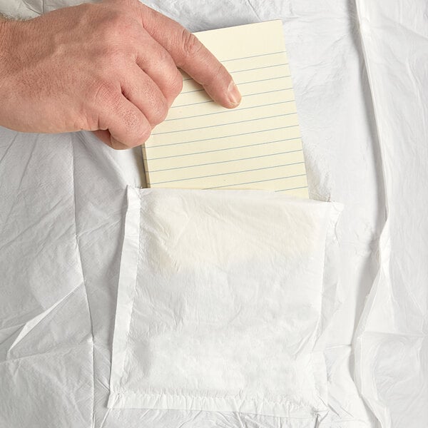 A person holding a note in the pocket of a white Malt Impact lab coat.