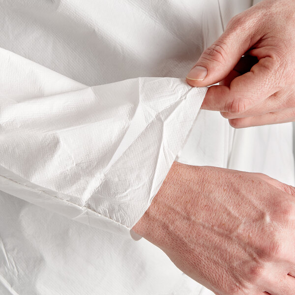 A person's hands pulling a white Malt Impact ProMax coverall out of the sleeve