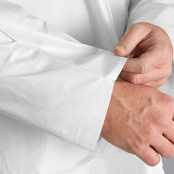 A person wearing a white Malt Impact ProMax lab coat adjusting their shirt.
