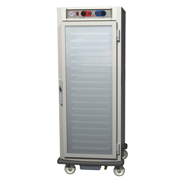 A stainless steel Metro C5 holding and proofing cabinet with clear glass doors on wheels.