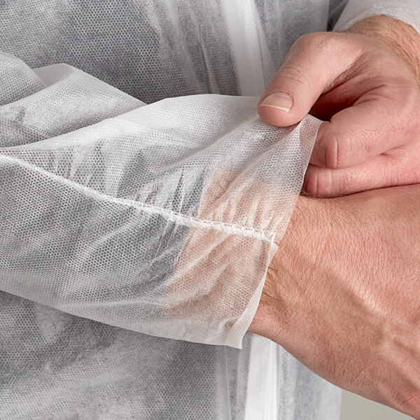 A person wearing Malt Polypropylene coveralls over a white shirt.