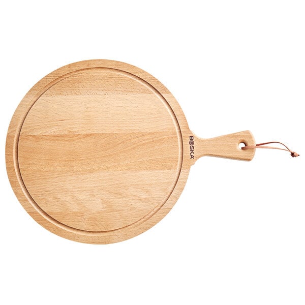 A Boska round beech wood serving board with a handle.