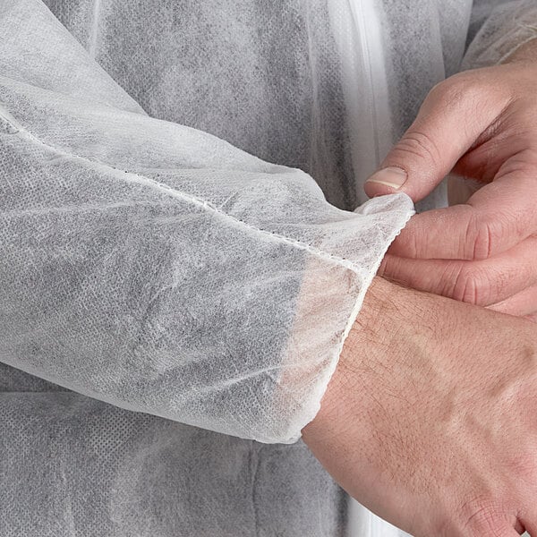 A person wearing white PolyLite coveralls with elastic wrists and ankles.
