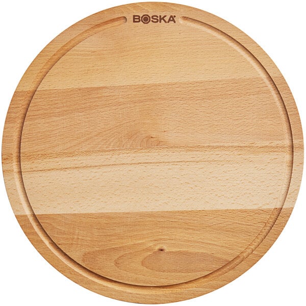 A Boska round beech wood serving board on a table.