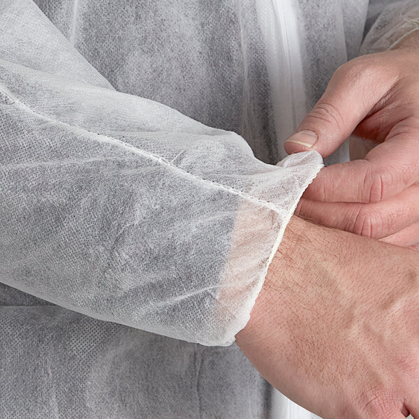 A person wearing white Malt Impact coveralls with elastic wrists and ankles.