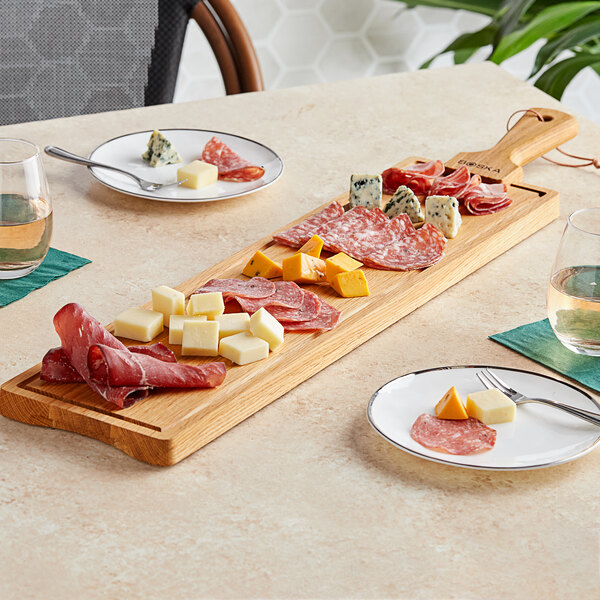 A Boska large oak serving board with meat and cheese on it.