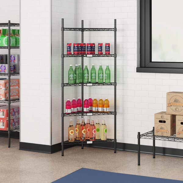 A black Regency wire shelf with beverages and boxes on it.