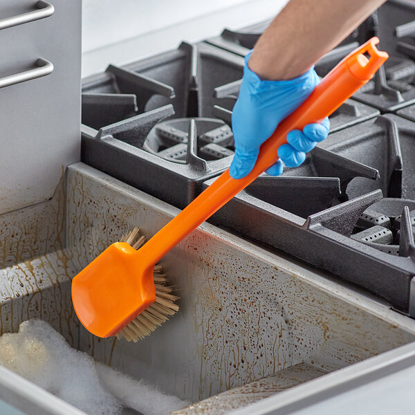 scrubbing inside of fryer with brush