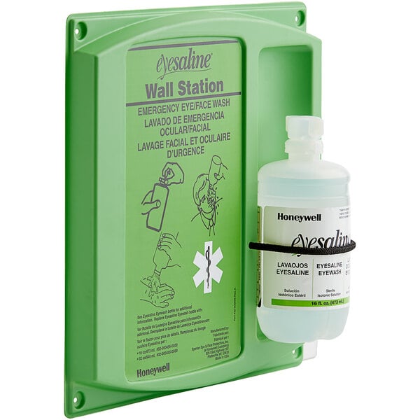 A green wall station with a Honeywell Eyesaline bottle of eye wash.