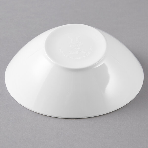 A white slanted melamine bowl on a gray surface.