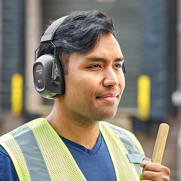 a man wearing headphones and a vest